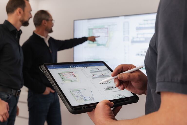 Planbesprechung mit Tablet und Bildschirm
