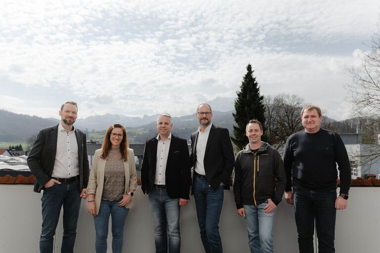 Das Planarium-Team auf der Terrasse vor den Bergen